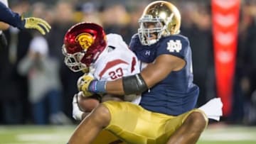 Oct 17, 2015; South Bend, IN, USA; USC Trojans running back Tre Madden (23) is tackled by Notre Dame Fighting Irish defensive lineman Romeo Okwara (45) in the fourth quarter at Notre Dame Stadium. Notre Dame won 41-31. Mandatory Credit: Matt Cashore-USA TODAY Sports
