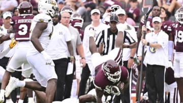 Sep 2, 2023; Starkville, Mississippi, USA; Mississippi State Bulldogs running back Jo'Quavious Marks (7) dives over Southeastern Louisiana Lions defensive back Ian Goodly (4) during the second quarter at Davis Wade Stadium at Scott Field. Mandatory Credit: Matt Bush-USA TODAY Sports