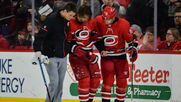 RALEIGH, NC - JANUARY 14: Carolina Hurricanes Center Marcus Kruger (16) helps Carolina Hurricanes Left Wing Sebastian Aho (20) off the ice after getting struck in the head during a game between the Calgary Flames and the Carolina Hurricanes at the PNC Arena in Raleigh, NC on January 14, 2017. Calgary defeated Carolina 4-1. (Photo by Greg Thompson/Icon Sportswire via Getty Images)