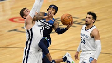 MINNEAPOLIS, MINNESOTA - JANUARY 13: D'Angelo Russell #0 of the Minnesota Timberwolves shoots the ball Jonas Valanciunas #17 and Dillon Brooks #24 of the Memphis Grizzlies during the first quarter of the game at Target Center on January 13, 2021 in Minneapolis, Minnesota. NOTE TO USER: User expressly acknowledges and agrees that, by downloading and or using this Photograph, user is consenting to the terms and conditions of the Getty Images License Agreement (Photo by Hannah Foslien/Getty Images)