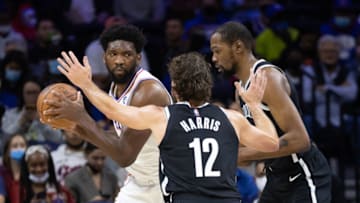 Oct 11, 2021; Philadelphia, Pennsylvania, USA; Philadelphia 76ers center Joel Embiid (left) controls the ball against Brooklyn Nets forward Joe Harris (12) and forward Kevin Durant (right) during the first quarter at Wells Fargo Center. Mandatory Credit: Bill Streicher-USA TODAY Sports