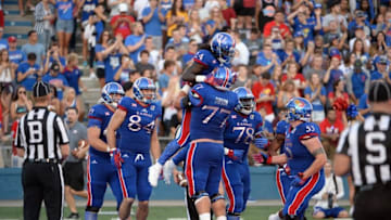 Sep 3, 2016; Lawrence, KS, USA; Kansas Jayhawks running back Taylor Martin (24) is congratulated by offensive lineman Joe Gibson (77) after scoring a touchdown against the Rhode Island Rams in the first half at Memorial Stadium. Mandatory Credit: John Rieger-USA TODAY Sports