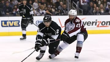 LOS ANGELES, CA - DECEMBER 21: Slava Voynov #26 of the Los Angeles Kings fights for the puck with Maxime Talbot #25 of the Colorado Avalanche at Staples Center on December 21, 2013 in Los Angeles, California. (Photo by Stephen Dunn/Getty Images)