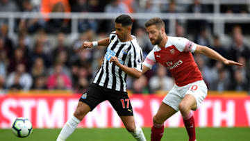 NEWCASTLE UPON TYNE, ENGLAND - SEPTEMBER 15: Ayoze Perez of Newcastle United (L) is challenged by Shkodran Mustafi of Arsenal during the Premier League match between Newcastle United and Arsenal FC at St. James Park on September 15, 2018 in Newcastle upon Tyne, United Kingdom. (Photo by Stu Forster/Getty Images)