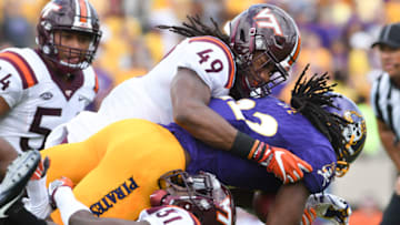 GREENVILLE, NC - SEPTEMBER 16: Running back Tyshon Dye #22 of the East Carolina Pirates is tackled by linebacker Tremaine Edmunds #49 and cornerback Brandon Facyson #31 of the Virginia Tech Hokies in the first half at Dowdy-Ficklen Stadium on September 16, 2017 in Greenville, North Carolina. (Photo by Michael Shroyer/Getty Images)