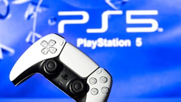 SPAIN - 2021/11/08: In this photo illustration, a PlayStation 5 controller seen with a PlayStation 5 logo in the background. (Photo Illustration by Thiago Prudencio/SOPA Images/LightRocket via Getty Images)