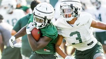 Michigan State's Jayden Reed, left, runs with the ball as Xavier Henderson closes in during the opening day of fall camp on Thursday, Aug. 5, 2021, on the MSU campus in East Lansing.210805 Msu Fball Camp 028a