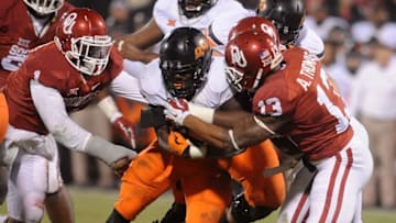 Dec 6, 2014; Norman, OK, USA; Oklahoma State Cowboys running back Desmond Roland (26) runs the ball against Oklahoma Sooners safety Ahmad Thomas (13) during the fourth quarter at Gaylord Family - Oklahoma Memorial Stadium. Mandatory Credit: Mark D. Smith-USA TODAY Sports