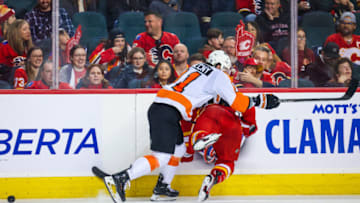 Feb 20, 2023; Calgary, Alberta, CAN; Philadelphia Flyers right wing Travis Konecny (11) checks into the boards Calgary Flames left wing Andrew Mangiapane (88) during the second period at Scotiabank Saddledome. Mandatory Credit: Sergei Belski-USA TODAY Sports