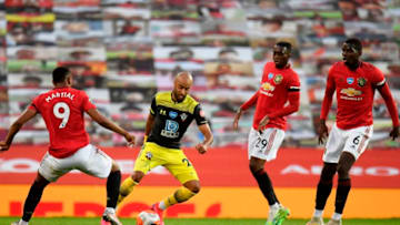 Southampton's English midfielder Nathan Redmond (2nd L) vies with Manchester United's French striker Anthony Martial (L), Manchester United's English defender Aaron Wan-Bissaka (2nd R) and Manchester United's French midfielder Paul Pogba (R) during the English Premier League football match between Manchester United and Southampton at Old Trafford in Manchester, north-west England, on July 13, 2020. (Photo by PETER POWELL / POOL / AFP) / RESTRICTED TO EDITORIAL USE. No use with unauthorized audio, video, data, fixture lists, club/league logos or 'live' services. Online in-match use limited to 120 images. An additional 40 images may be used in extra time. No video emulation. Social media in-match use limited to 120 images. An additional 40 images may be used in extra time. No use in betting publications, games or single club/league/player publications. / (Photo by PETER POWELL/POOL/AFP via Getty Images)