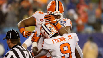 CHARLOTTE, NC - DECEMBER 01: Christian Wilkins #42 and teammate Travis Etienne #9 of the Clemson Tigers celebrate a touchdown against the Pittsburgh Panthers in the first quarter at Bank of America Stadium on December 1, 2018 in Charlotte, North Carolina. (Photo by Streeter Lecka/Getty Images)