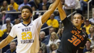 Jan 9, 2016; Morgantown, WV, USA; Oklahoma State Cowboys guard Jeffrey Carroll (30) shoots a three pointer over West Virginia Mountaineers forward Esa Ahmad (23) during the second half at the WVU Coliseum. Mandatory Credit: Ben Queen-USA TODAY Sports