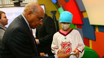 RALEIGH, NC - JANUARY 28: Former NHL player Willie O'Ree signs an autograph for a patient during the Lion's Den "Champions in Courage" North Carolina Chidren's Hospital Chapel Hill visit as part of 2011 NHL All-Star Weekend on January 28, 2011 in Raleigh, North Carolina. (Photo by Bill Wippert/NHLI via Getty Images)