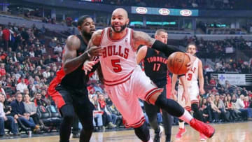 Dec 31, 2013; Chicago, IL, USA; Chicago Bulls power forward Carlos Boozer (5) drives past Toronto Raptors power forward Amir Johnson (15) during the first quarter at the United Center. Mandatory Credit: Dennis Wierzbicki-USA TODAY Sports