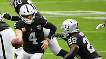 LAS VEGAS, NEVADA - OCTOBER 25: Quarterback Derek Carr #4 of the Las Vegas Raiders hands the ball off to running back Josh Jacobs #28 during the first half of their game against the Tampa Bay Buccaneers at Allegiant Stadium on October 25, 2020 in Las Vegas, Nevada. The Buccaneers defeated the Raiders 45-20. (Photo by Ethan Miller/Getty Images)
