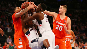 NEW YORK, NY - DECEMBER 05: Christian Vital #1 and Amida Brimah #35 of the Connecticut Huskies battle for control of the ball against Ray Featherston #35 and Tyler Lydon #20 of the Syracuse Orange during the Tire Pros Classic at Madison Square Garden on December 5, 2016 in New York City. Connecticut defeated Syracuse 52-50 (Photo by Mike Stobe/Getty Images)