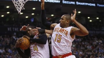 Mar 30, 2016; Toronto, Ontario, CAN; Atlanta Hawks forward Paul Millsap (4) grabs a rebound against Toronto Raptors center Jonas Valanciunas (17) and Atlanta Hawks center Al Horford (15) for a rebound during the first half at the Air Canada Centre. Mandatory Credit: John E. Sokolowski-USA TODAY Sports