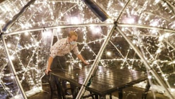 The restaurant supervisor Taylor Farmer sets up tables in igloos outside of the Vivante French Eatery off the Monon in Carmel, Ind., Tuesday, Nov. 24, 2020. Igloos at multiple locations stretched on the Monon including Vivante French Eatery, Midtown Plaza and near Anthony’s Chophouse.Ini Carmel Christmas