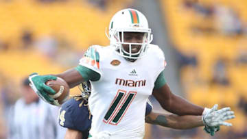Nov 27, 2015; Pittsburgh, PA, USA; Miami Hurricanes wide receiver Rashawn Scott (11) runs after a catch against Pittsburgh Panthers defensive back Avonte Maddox (14) during the fourth quarter at Heinz Field. Miami won 29-24. Mandatory Credit: Charles LeClaire-USA TODAY Sports