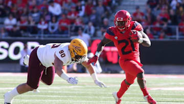 TUCSON, AZ - NOVEMBER 24: Running back J.J. Taylor #21 of the Arizona Wildcats runs the ball as defensive lineman Jermayne Lole #90 of the Arizona State Sun Devils tries to make a tackle during the first half of the college football game at Arizona Stadium on November 24, 2018 in Tucson, Arizona. (Photo by Ralph Freso/Getty Images)