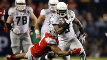 Jan 12, 2015; Arlington, TX, USA; Oregon Ducks running back Byron Marshall (9) runs the ball against Ohio State Buckeyes linebacker Joshua Perry (37) during the second quarter in the 2015 CFP National Championship Game at AT&T Stadium. Mandatory Credit: Tim Heitman-USA TODAY Sports