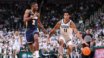 EAST LANSING, MI - DECEMBER 04: A.J. Hoggard #11 of the Michigan State Spartans handles the ball under pressure from E.J. Farmer #2 of the Toledo Rockets in the first half at Breslin Center on December 4, 2021 in East Lansing, Michigan. (Photo by Rey Del Rio/Getty Images)