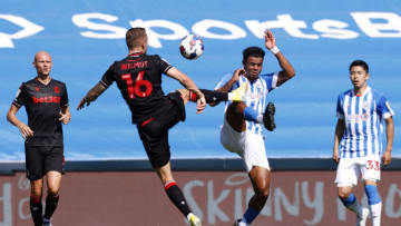 HUDDERSFIELD, ENGLAND - AUGUST 13: Tino Anjorin of Huddersfield Town clashes with Ben Wilmot of Stoke City to win a high bouncing ball during the Sky Bet Championship match between Huddersfield Town and Stoke City at The John Smith's Stadium on August 13, 2022 in Huddersfield, England. (Photo by John Early/Getty Images)