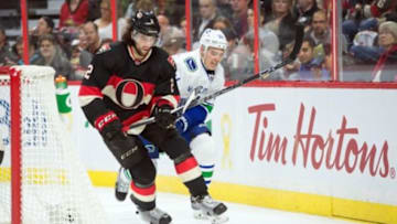 Nov 12, 2015; Ottawa, Ontario, CAN; Ottawa Senators defenseman Jared Cowen (2) and Vancouver Canucks right wing Andrew Cracknell (24) battle for the puck in the second period at Canadian Tire Centre. Mandatory Credit: Marc DesRosiers-USA TODAY Sports