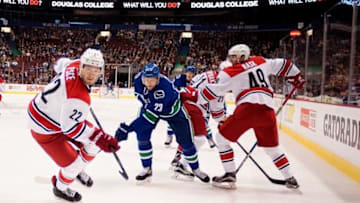 Oct 16, 2016; Vancouver, British Columbia, CAN; Vancouver Canucks defenseman Alexander Edler (23) and Carolina Hurricanes defenseman Brett Pesce (22) skate into the corner to retrieve the puck during the first period at Rogers Arena. The Vancouver Canucks won 4-3 in overtime. Mandatory Credit: Anne-Marie Sorvin-USA TODAY Sports