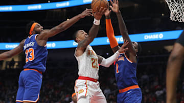 Mar 11, 2020; Atlanta, Georgia, USA; Atlanta Hawks forward John Collins (20) shoots against New York Knicks center Mitchell Robinson (23) and forward Bobby Portis (1) in the second half at State Farm Arena. Mandatory Credit: Jason Getz-USA TODAY Sports