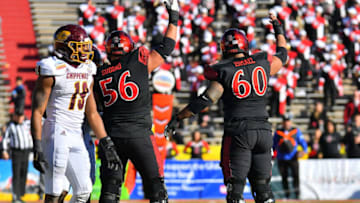 ALBUQUERQUE, NEW MEXICO - DECEMBER 21: Offensive lineman Dominic Gudino #56 and offensive lineman Keith Ismael #60 of the San Diego State Aztecs signal to the sideline for medical trainers after teammate wide receiver Ethan Dedeaux #81 was injured after a helmet-to-helmet hit from defensive back Willie Reid #19 of the Central Michigan Chippewas during the New Mexico Bowl at Dreamstyle Stadium on December 21, 2019 in Albuquerque, New Mexico. Reid was called for targeting on the play and was ejected from the game. The Aztecs defeated the Chippewas 48-11. (Photo by Sam Wasson/Getty Images)