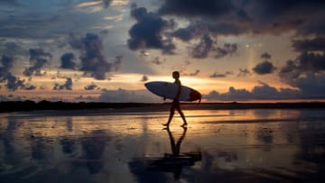 MAL PAIS, COSTA RICA - JUNE 13: A female surfer walks down beach during sunset on June 13, 2015 in Mal Pais, Costa Rica. (Photo by Gabe LHeureux/Getty Images)