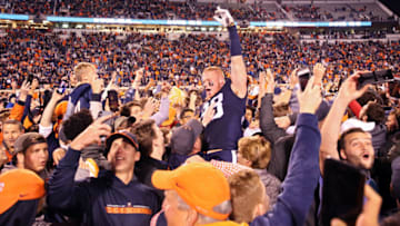 CHARLOTTESVILLE, VA - OCTOBER 13: Fans of the Virginia Cavaliers rush the field to celebrate with players including Zane Zandier #33 after winning a game against the Miami Hurricanes at Scott Stadium on October 13, 2018 in Charlottesville, Virginia. (Photo by Ryan M. Kelly/Getty Images)