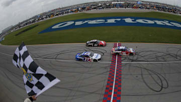 JOLIET, IL - JULY 01: Kyle Busch, driver of the #18 Skittles Red White & Blue Toyota, takes the checkered flag to win the Monster Energy NASCAR Cup Series Overton's 400 at Chicagoland Speedway on July 1, 2018 in Joliet, Illinois. (Photo by Matt Sullivan/Getty Images)