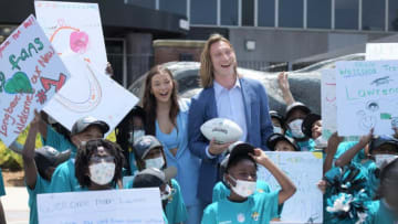 Trevor Lawrence and his wife Marissa pose with students from Long Branch Elementary School upon their arrival in Jacksonville Friday. The Jacksonville Jaguars' first-round draft pick Trevor Lawrence and his wife Marissa arrived at TIAA Bank Field in Jacksonville, Florida about noon Friday, April 30, 2021. The couple was greeted by team owner Shad Khan and 35 third-grade students from Long Branch Elementary School. [Bob Self/Florida Times-Union]Jki 043021 Trevorlawrencea