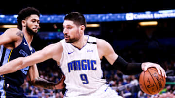 ORLANDO, FLORIDA - MARCH 22: Nikola Vucevic #9 of the Orlando Magic attempts to pass Tyler Dorsey #22 of the Memphis Grizzlies in the fourth quarter at Amway Center on March 22, 2019 in Orlando, Florida. NOTE TO USER: User expressly acknowledges and agrees that, by downloading and or using this photograph, User is consenting to the terms and conditions of the Getty Images License Agreement. (Photo by Harry Aaron/Getty Images)