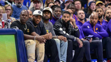 Dec 5, 2022; Dallas, Texas, USA; (from left) Dallas Cowboys linebacker Micah Parsons (white hat) and cornerback Trevon Diggs (white hat) and wide receiver free agent Odell Beckham Jr. (black jacket) watch the game between the Dallas Mavericks and the Phoenix Suns during the second quarter at the American Airlines Center. Mandatory Credit: Jerome Miron-USA TODAY Sports