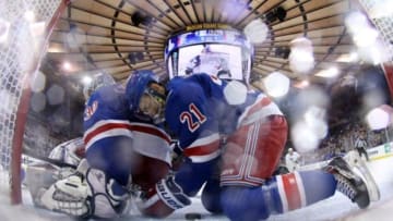 Jun 11, 2014; New York, NY, USA; New York Rangers center Derek Stepan (21) swats the puck from off the goal line behind goalie Henrik Lundqvist (30) during the third period in game four of the 2014 Stanley Cup Final against the Los Angeles Kings at Madison Square Garden. Mandatory Credit: Bruce Bennett/Pool Photo via USA TODAY Sports