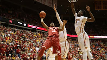 Jan 18, 2016; Ames, IA, USA; Oklahoma Sooners guard Isaiah Cousins (11) splits the defense of Iowa State Cyclones forward Abdel Nader (2) and forward Jameel McKay (1) at James H. Hilton Coliseum. Mandatory Credit: Reese Strickland-USA TODAY Sports