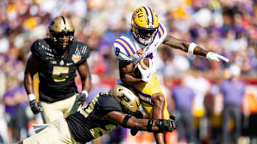 Jan 2, 2023; Orlando, FL, USA; LSU Tigers wide receiver Malik Nabers (8) leaps over Purdue Boilermakers linebacker OC Brothers (20) during the first half at Camping World Stadium. Mandatory Credit: Matt Pendleton-USA TODAY Sports