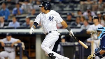 Jul 1, 2014; Bronx, NY, USA; New York Yankees third baseman Yangervis Solarte (26) hits a single against the Tampa Bay Rays during the fifth inning at Yankee Stadium. Mandatory Credit: Brad Penner-USA TODAY Sports