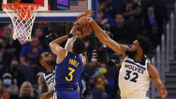 Jordan Poole of the Golden State Warriors goes up for a shot on D'Angelo Russell and Karl-Anthony Towns of the Minnesota Timberwolves. (Photo by Ezra Shaw/Getty Images)