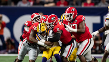 ATLANTA, GA - DECEMBER 3: John Emery Jr. #4 of the LSU Tigers is stopped by Smael Mondon Jr. #2, Trezmen Marshall #15 of the Georgia Bulldogs after a short gain during a game between LSU Tigers and Georgia Bulldogs at Mercedes-Benz Stadium on December 3, 2022 in Atlanta, Georgia. (Photo by Steve Limentani/ISI Photos/Getty Images)