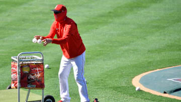 ANAHEIM, CA - AUGUST 10: Los Angeles Angels pitching coach Mickey Callaway gathers baseballs while wearing a mask before the game against the Oakland Athletics at Angel Stadium of Anaheim on August 10, 2020 in Anaheim, California. (Photo by John McCoy/Getty Images)