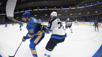 ST. LOUIS, MO - NOVEMBER 24: St. Louis Blues leftwing Zach Sanford (12) and Winnipeg Jets defenseman Joe Morrow (70) compete for the puck during a NHL game between the Winnipeg Jets and the St. Louis Blues on November 24, 2018, at Enterprise Center, St. Louis, MO. (Photo by Keith Gillett/Icon Sportswire via Getty Images)