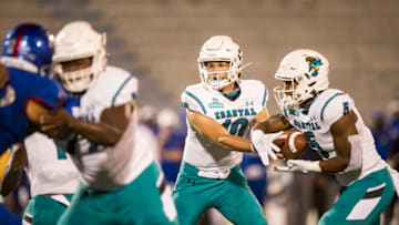 LAWRENCE, KS - SEPTEMBER 12: Quarterback Grayson McCall #10 of the Coastal Carolina Chanticleers hands the ball off to running back Shermari Jones #5 at Memorial Stadium on September 12, 2020 in Lawrence, Kansas. (Photo by Brian Davidson/Getty Images)