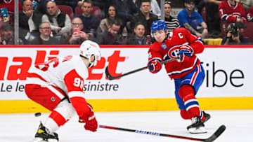 Apr 4, 2023; Montreal, Quebec, CAN; Montreal Canadiens center Nick Suzuki (14) shoots the puck beside Detroit Red Wings defenseman Jake Walman (96) during the second period at Bell Centre. Mandatory Credit: David Kirouac-USA TODAY Sports