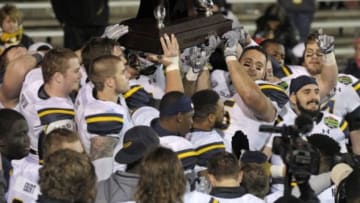 Jan 4, 2015; Mobile, AL, USA; Toledo Rockets players hold up the GoDaddy Bowl champion trophy after defeating the Arkansas State Red Wolves in the 2015 GoDaddy Bowl at Ladd-Peebles Stadium. Toledo defeated Arkansas State, 63-44. Mandatory Credit: Glenn Andrews-USA TODAY Sports