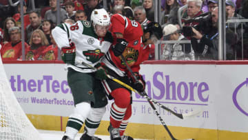 CHICAGO, IL - NOVEMBER 18: Nick Seeler #36 of the Minnesota Wild and Andreas Martinsen #29 of the Chicago Blackhawks battle for the puck in the first period at the United Center on November 18, 2018 in Chicago, Illinois. (Photo by Bill Smith/NHLI via Getty Images)
