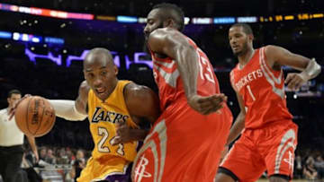 Oct 28, 2014; Los Angeles, CA, USA; Los Angeles Lakers guard Kobe Bryant (24) drives against Houston Rockets guard James Harden (13) and guard Trevor Ariza (1) during the second half at Staples Center. Mandatory Credit: Richard Mackson-USA TODAY Sports